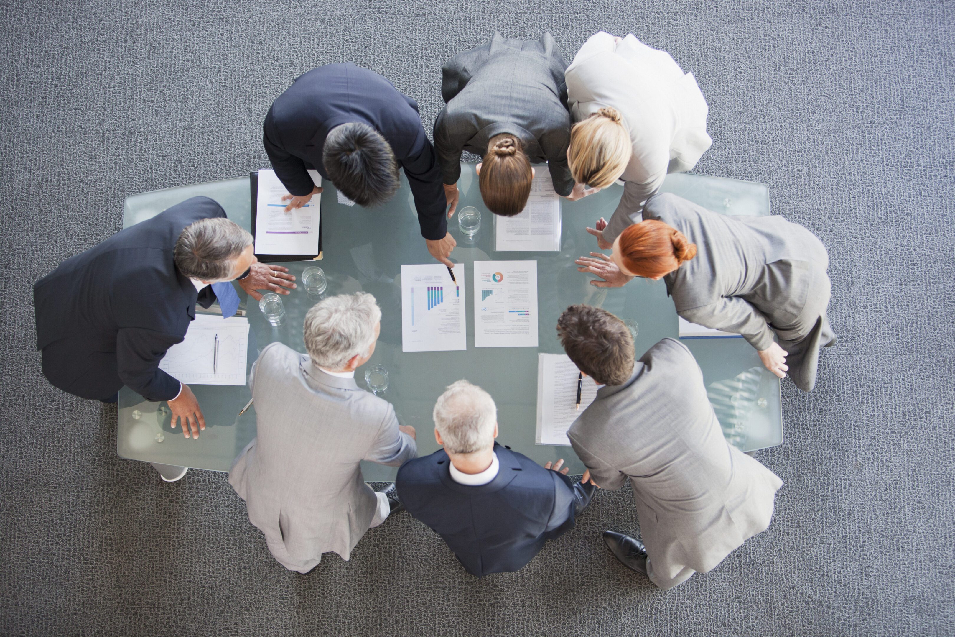 Business people huddled around paperwork on table