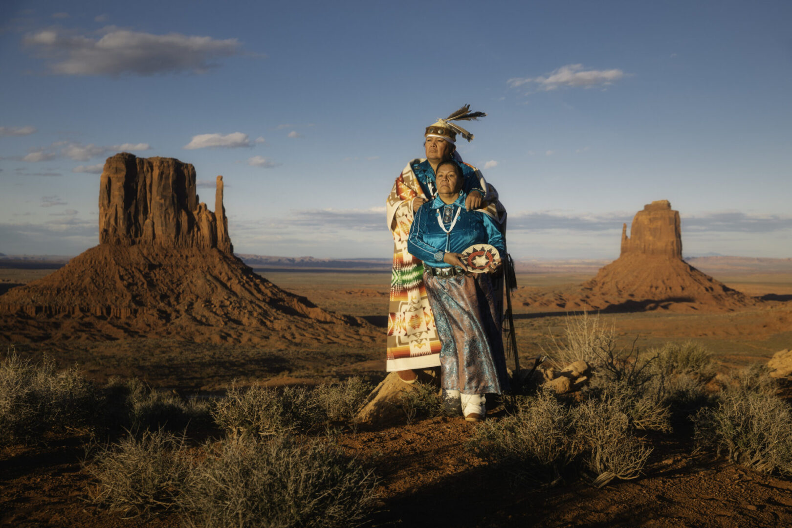 Portrait of a Navajo couple standing in front of the famous view in Monument Valley Tribal Park, Arizona.