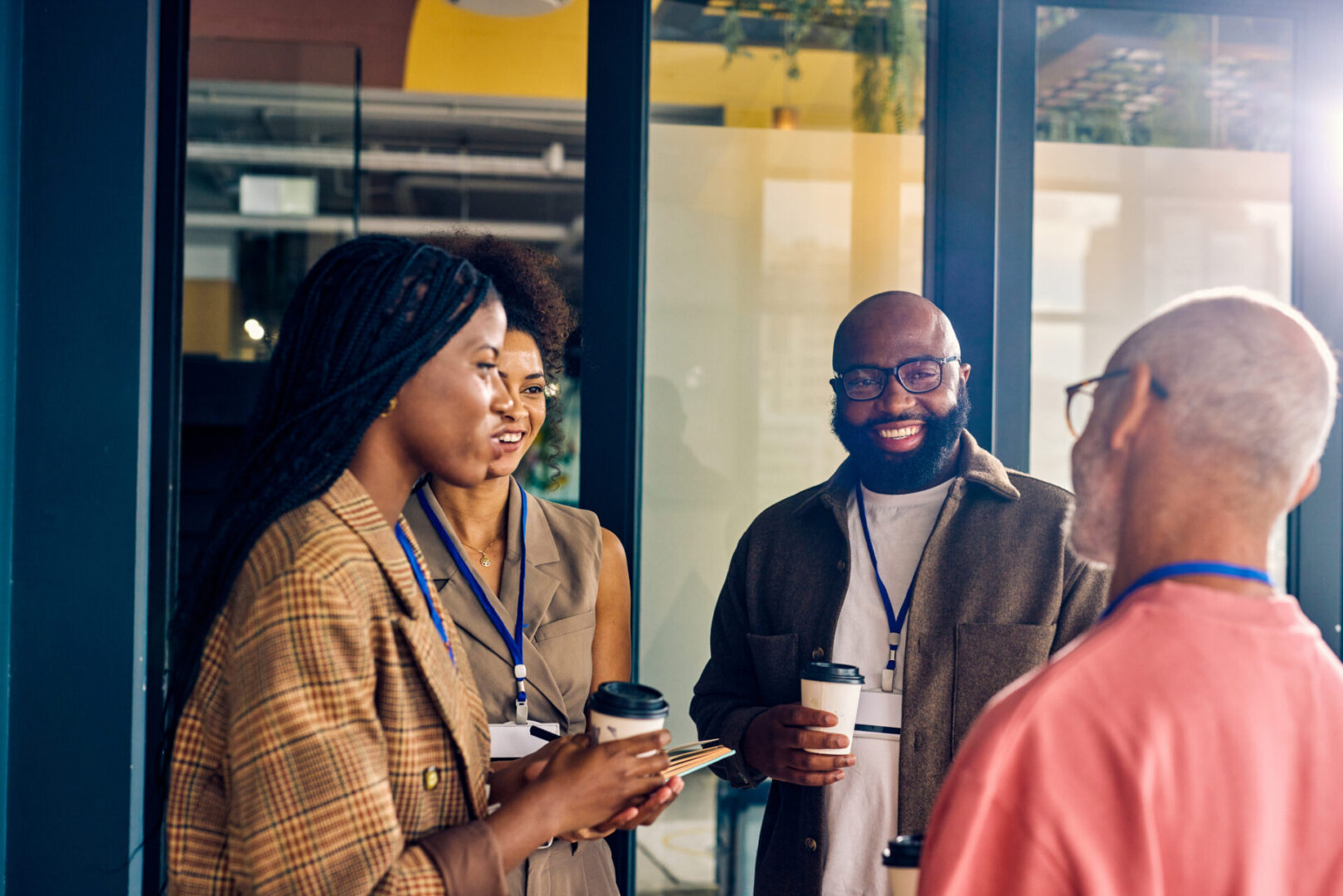 Multicultural business team during a coffee break in a corporate setting. Casual networking and employee engagement concept for design and print.
