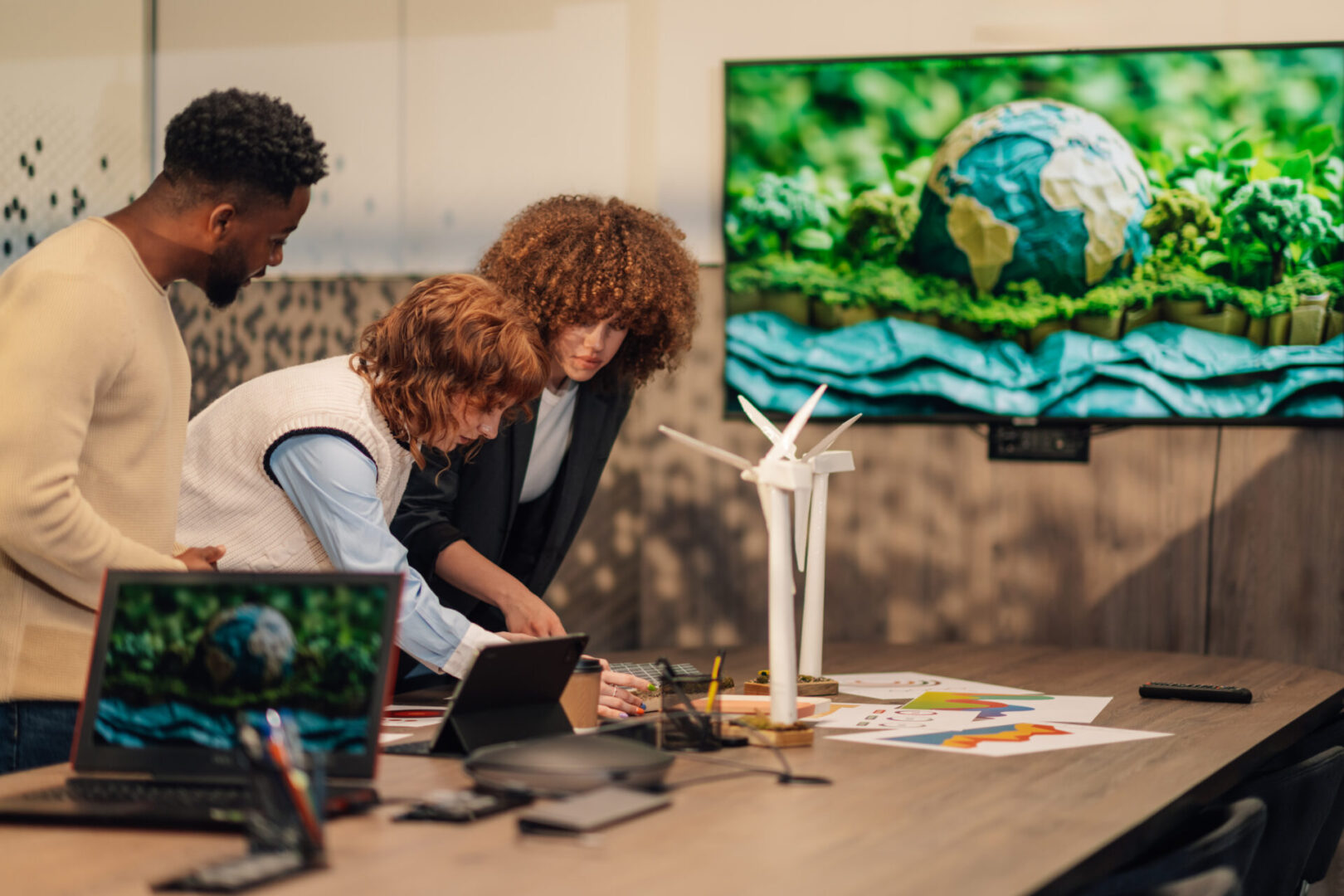 Multicultural ecology engineer standing at eco friendly boardroom and working on renewable energy project.Diverse environmentalists standing at meeting room and doing statistic for sustainable project