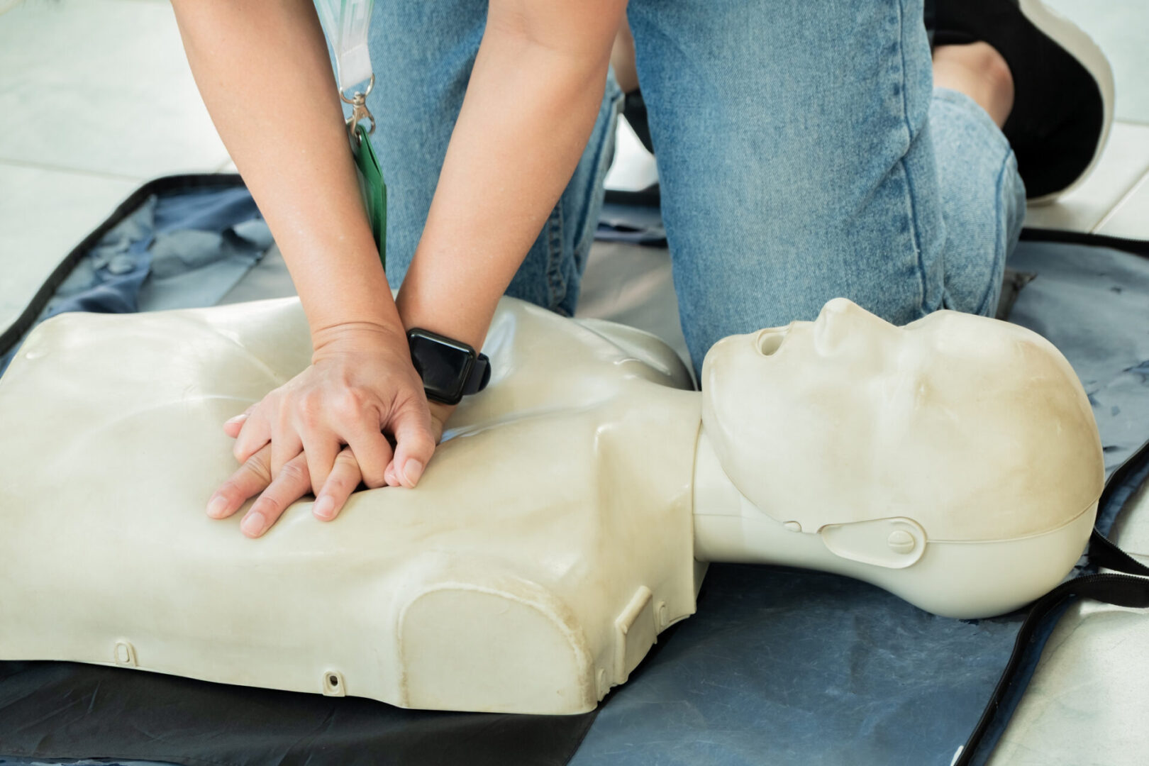 Person performing CPR chest compressions on a training dummy during first aid training. Concept for emergency response, lifesaving skills, or CPR certification