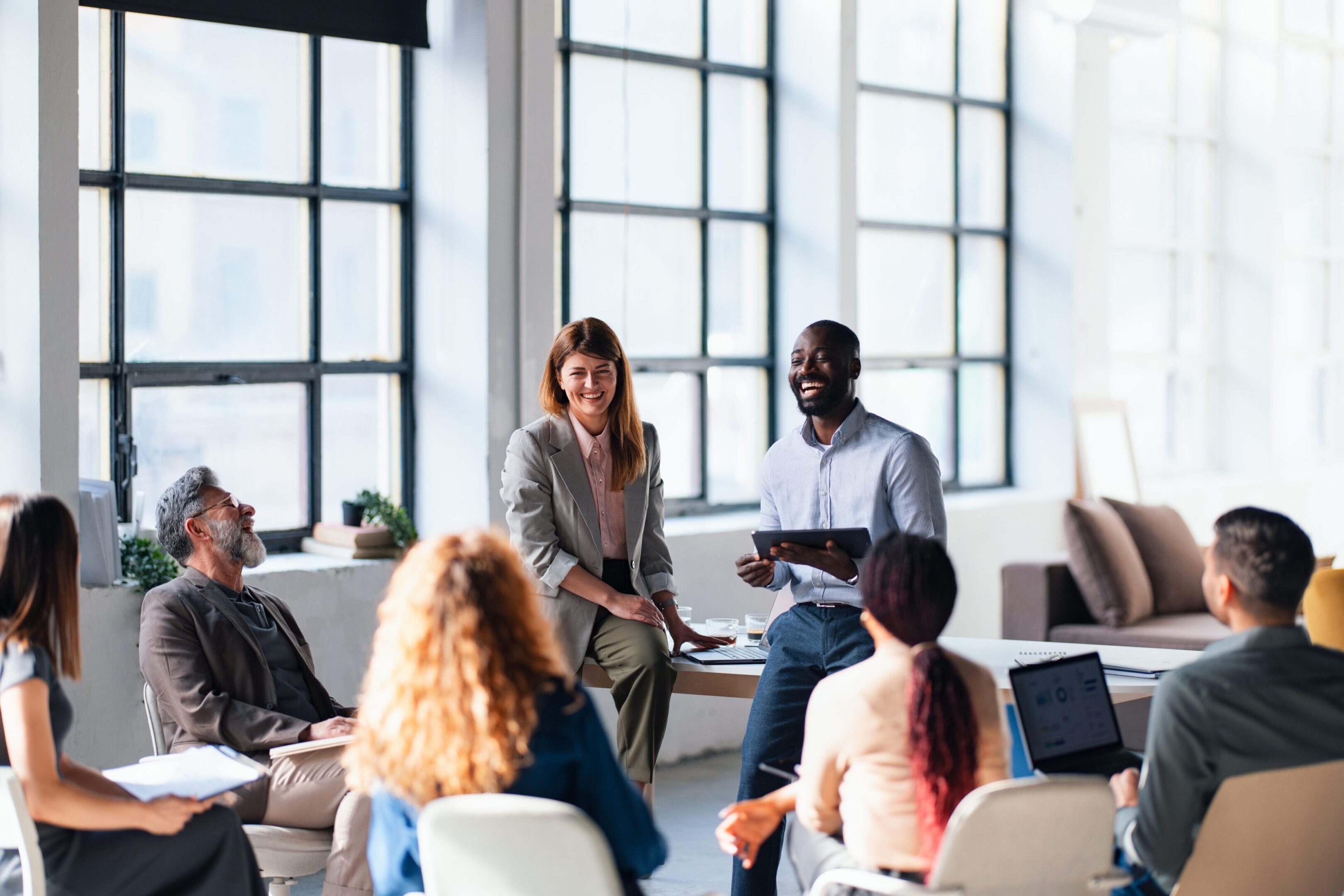 A collaborative group of professionals discussing ideas and strategies in a well-lit, modern office setting. The atmosphere is vibrant and productive, fostering teamwork and positive engagement.