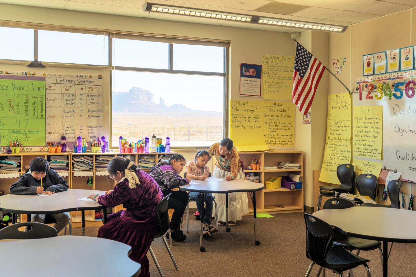 Teacher helping students with their work at school