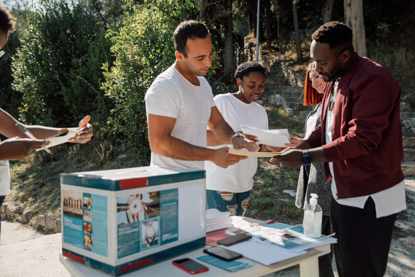 Multicultural group of young volunteers distribute flyers and leaflets in the street