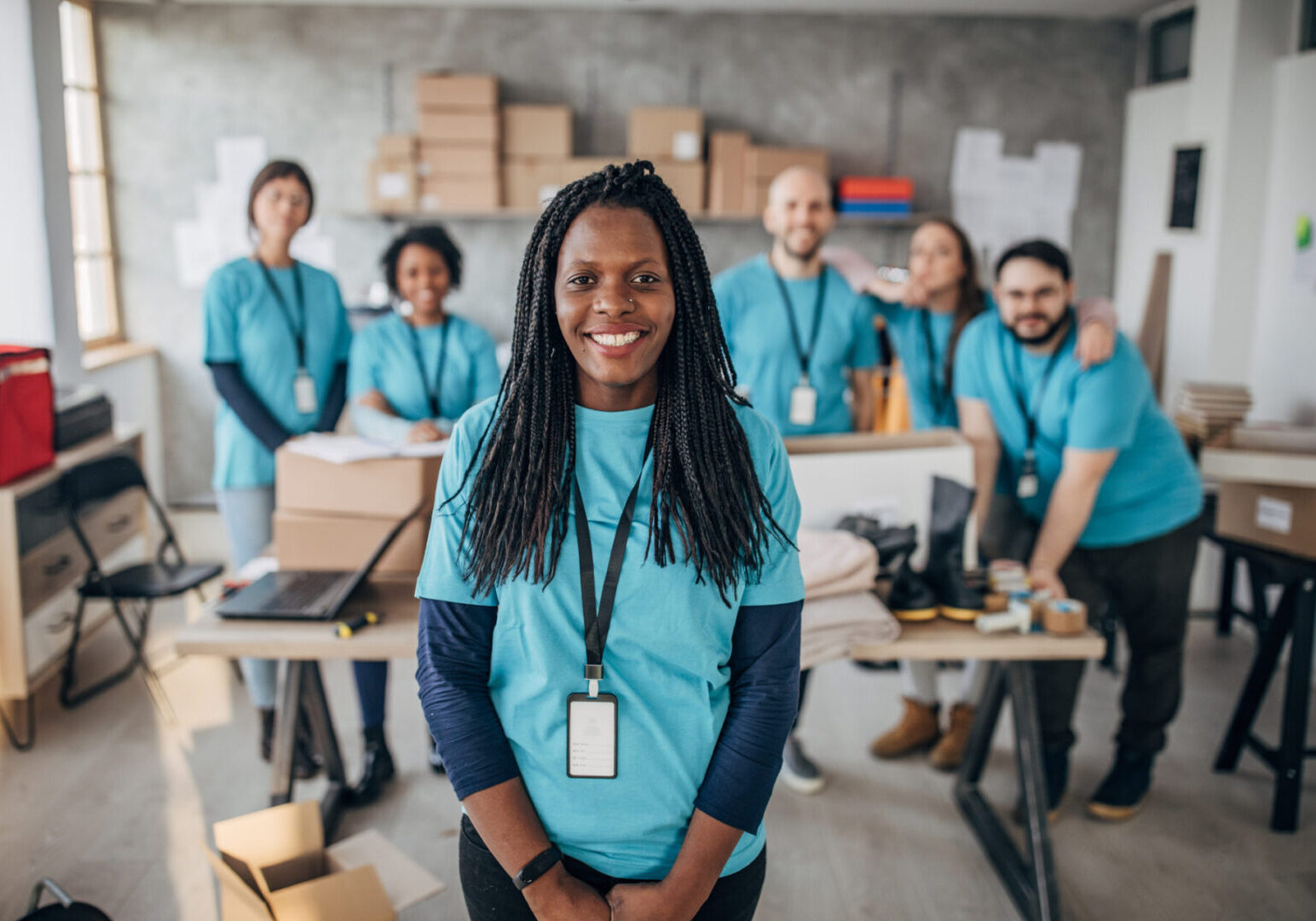 Multi-ethnic group of people, diverse volunteers packing donation boxes in charity food bank.