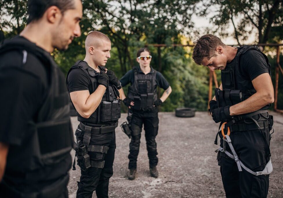 SWAT team training on training grounds outdoors together, they have a male drill instructor.