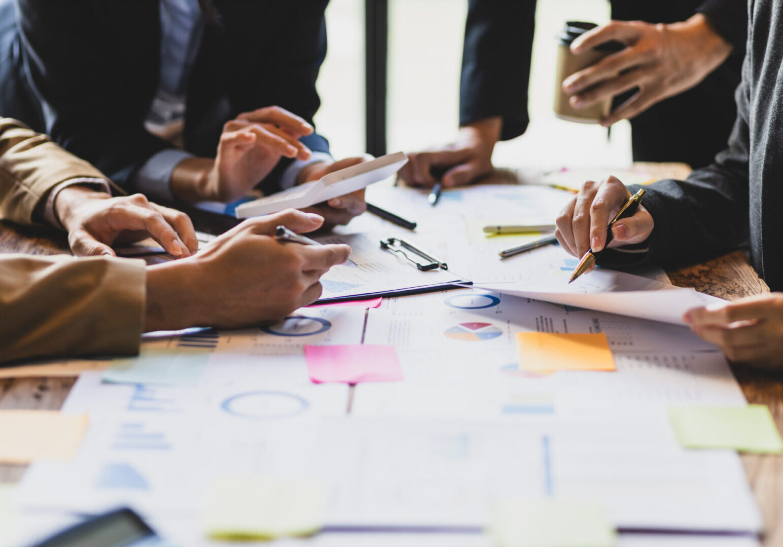 Brainstorm business meeting to discuss analysis of financial figures, graphs and growth charts of business investments to plan new business projects.