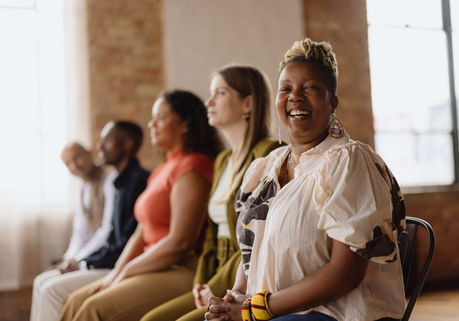 Cheerful african american businesswoman laughs during a meeting with colleagues in a modern office